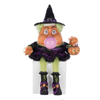 Front view of Katherine's Collection Bubbles the Witch, blowing a bubble and holding a pumpkin pail, dressed in satin and velvet.