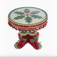 Top view of cake plate of the Festive Elf Boots Cake Plate by Katherine’s Collection (SKU 28-428347, GTIN 810074128339), food-safe resin tray with holly leaves and whimsical velvet elf shoes.
