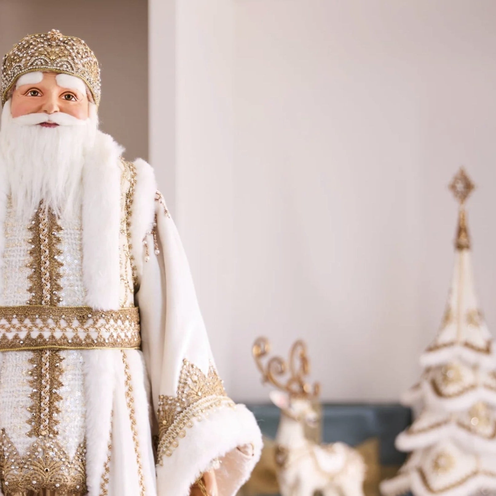 Man in a traditional Russian Christmas costume standing in a decorated room with a Christmas tree and gifts.