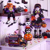 Halloween-themed decorations including dolls, pumpkins, and a truck on a shelf.