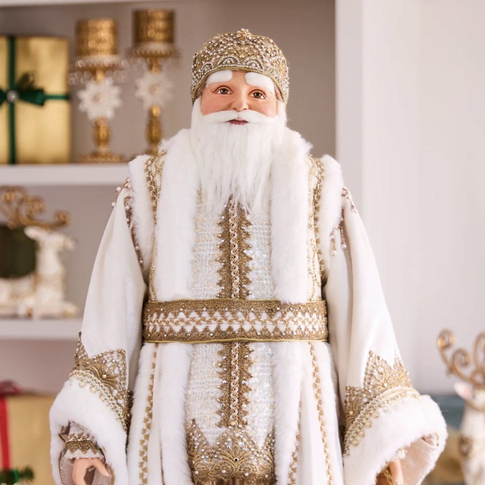 Man in a traditional Russian Christmas costume standing in a decorated room with a Christmas tree and gifts.