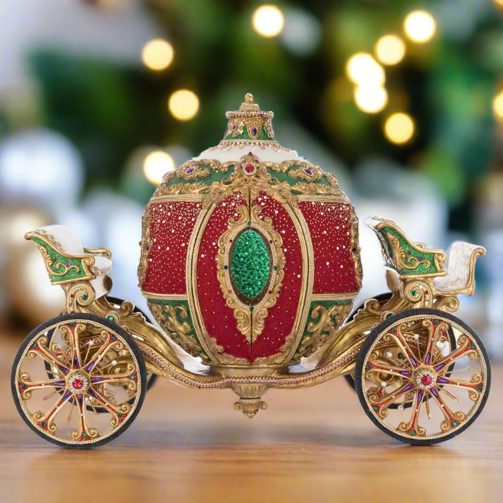 Katherine’s Collection Royal Christmas Ball Ornament Carriage in red and green with gold accents, crystal details, and gem-covered spoke wheels