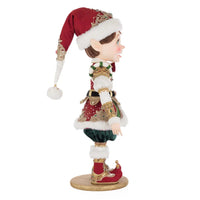 Close-up of William Wintersnap’s red elf hat with gold brocade and fluffy faux fur from Katherine’s Collection 2025 holiday collection