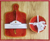 Le Cadeaux Bellini cutting board and cheese knife and le cadeaux Bellini holiday appetizer plates 097BEL on a wooden surface