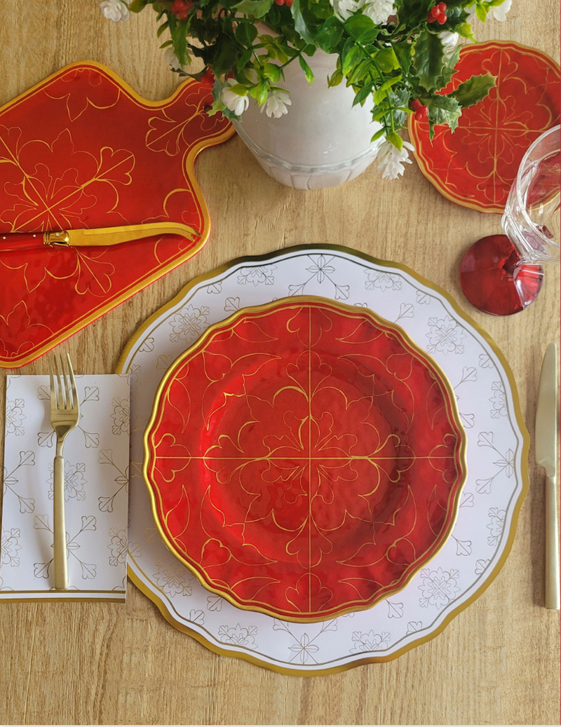 Decorative red and gold Le Cadeaux Bellini salad plate on a table with matching placemats and cutlery.