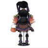 Decorative witch figurine with a pumpkin and broomstick on a white background