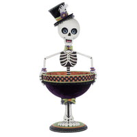 Decorative skeleton figure with a top hat holding a bowl on a white background