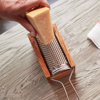 Detailed side angle showing the metal grater and olive wood catch box