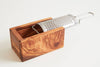 Detailed side angle showing the metal grater and olive wood catch box