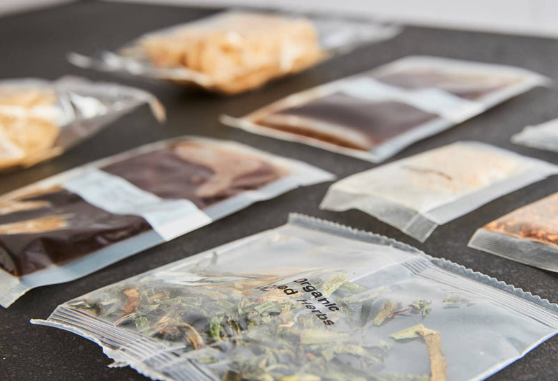 Close-up of organic rice noodles, sauce, garlic, herbs, and peanuts included in kit