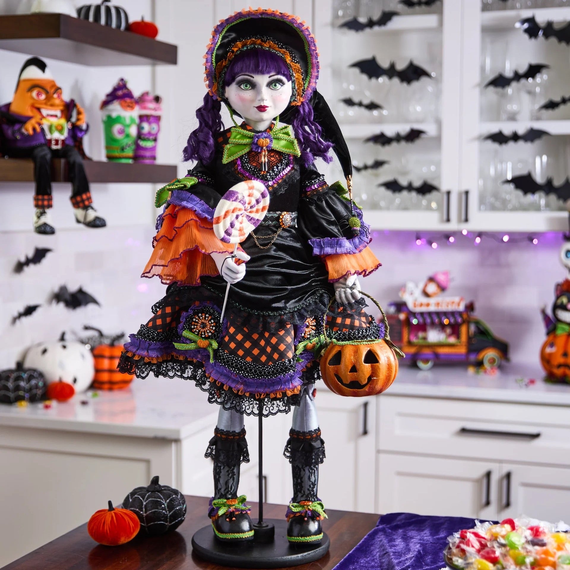 Halloween-themed doll with colorful outfit and pumpkin, set against a festive background.