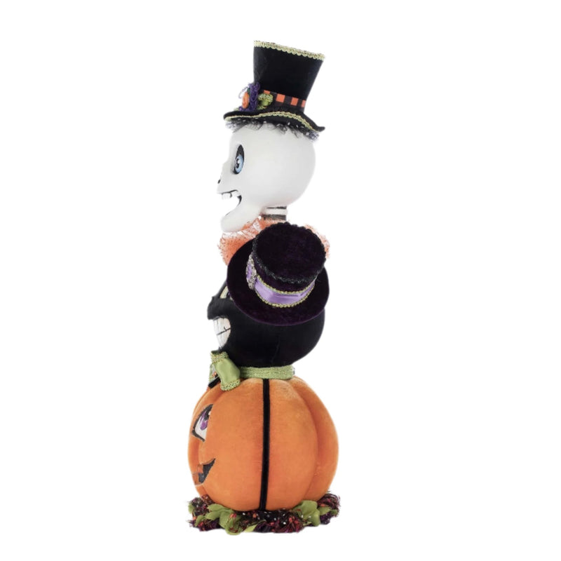 Side profile showing stacked sculpted figures and layered velvet textures with sparkle accents.