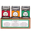Three tins of Spicewalla taco seasoning blends displayed together on a rustic kitchen counter
