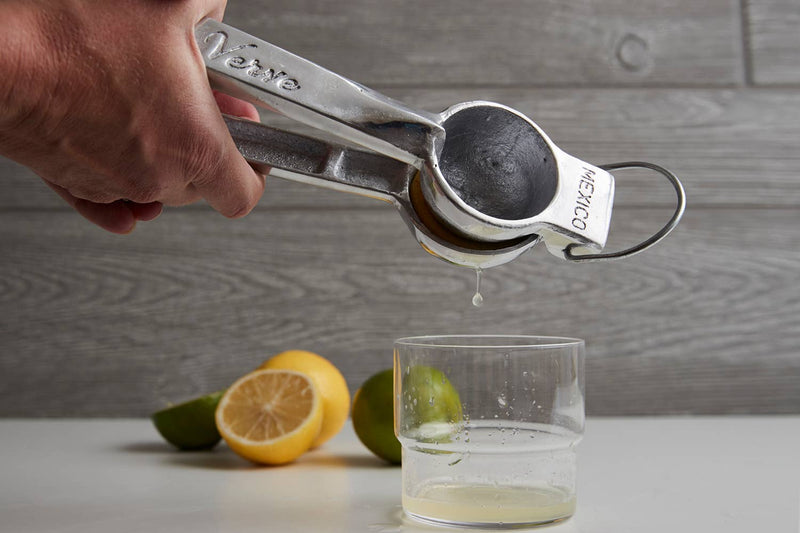 Verve Culture hand juicer displayed on a kitchen counter with lemons and limes