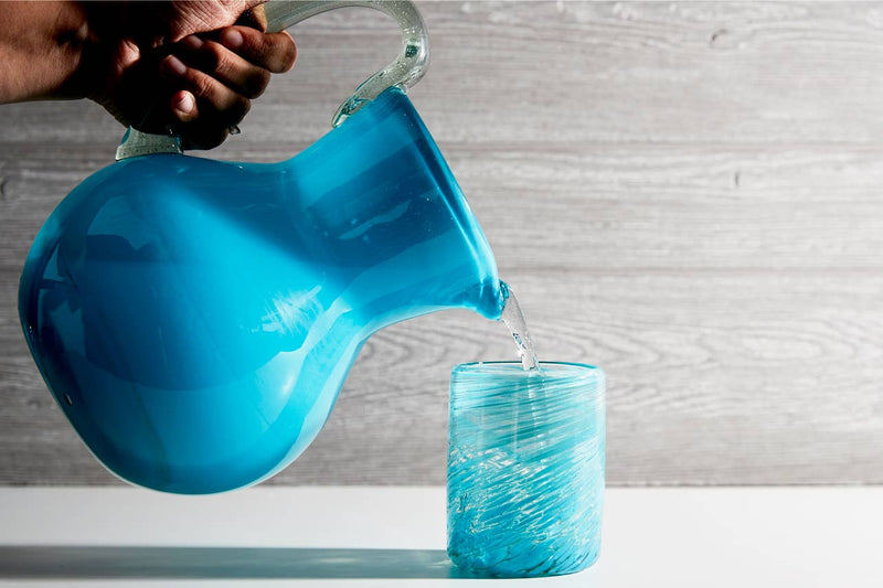Aqua handmade Glasses being filled with beverages by the coordinating aqua handmade pitchers on a styled table setting