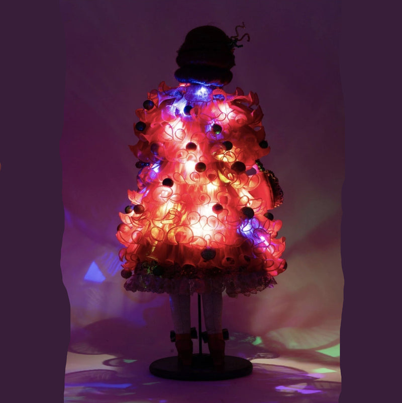 Holiday Magic Mae doll featuring hidden twinkle lights in her red tulle coat back view lit for night 