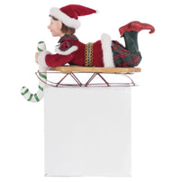 Side view of Holiday Magic Laying Elf on Sled Stocking Holder with velvet outfit