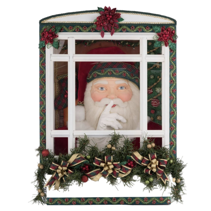 Decorative holiday window with Santa Claus figure and festive decorations on a white background.