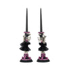 Two skeleton hand candle sticks with decorative elements on a white background.