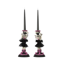 Pair of skeleton hand candle sticks with black and pink design on a white background