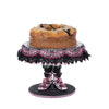 Katherine’s Collection Witch Boots Cake Plate displayed with Halloween cake, elegant hand-painted collectible dessert stand.
