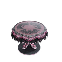 top view of Katherine’s Collection Witch Boots Cake Plate with glitter and lace bat wing design under clear food safe surface.