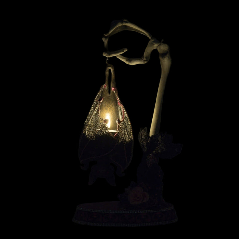 Katherine’s Collection Lacey Bat Luminary illuminated for night with included battery tea light, glowing lace wings and jeweled details.